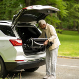 An older person inserts the Journey Zoomer® Folding Power Chair into a car’s trunk