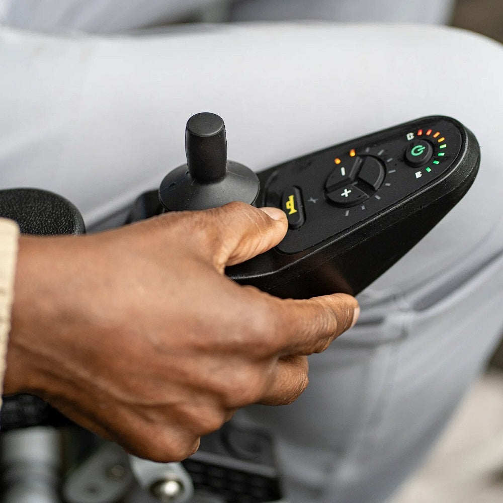 A man’s hand on the Journey Zoomer® Folding Power Chair right handed joystick control unit with buttons
